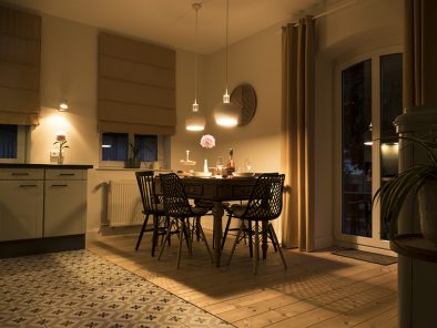 Die Küche der Mittelrhein-Ferienwohnung mit dem Esstisch in abendlicher Beleuchtung.