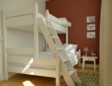 Familien-Etagenbett mit schräger Treppe vor einer roten Wand
