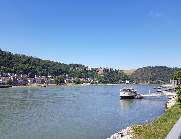 Eine Anlegestelle am Ufer bei St. Goarshauseen mit Blick auf den Rhein und St. Goar auf der gegenüberliegenden Rheinseite.