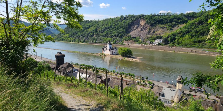 Blick ins Mittelrheintal auf die Burg Pfalzgrafenstein mit einem Wanderweg im Vordergrund